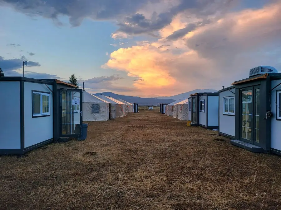 Rows of crew quarters at a fire camp at sunset